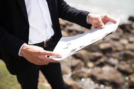 Makler mit einem Grundbuchauszug in der Hand