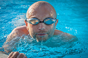 Mann der in einem Gartenpool schwimmt